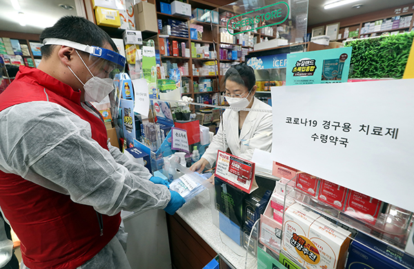 12일 오전 인천시 부평구 한 약국에서 열린 ‘코로나19 경구용(먹는) 치료제 투약 예행 연습’에서 부평구보건소 관계자가 치료제를 약국에서 수령해 환자에게 전달하는 연습을 하고 있다. (사진=저작권자(c) 연합뉴스, 무단 전재-재배포 금지)