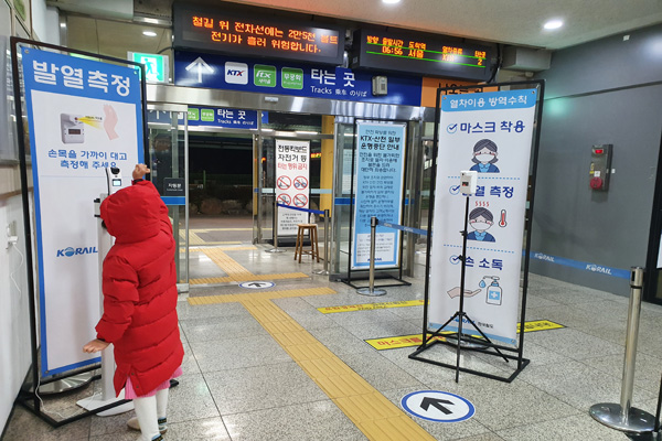 기차역 탑승구에는 철저한 방역수칙을 위해 8세 자녀가 체온측정기를 하고 있다.