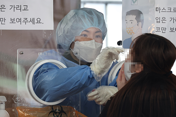 오미크론 변이 확산으로 신규 확진자 수가 빠르게 증가세로 돌아선 가운데 21일 오전 서울역 광장에 마련된 중구 임시 선별검사소에서 한 시민이 검사를 받고 있다. (사진=저작권자(c) 연합뉴스, 무단 전재-재배포 금지)