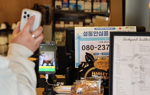 서울 시내 카페에서 방문 고객이 전자출입명부 QR코드를 태그하고 있다. (사진=저작권자(c) 연합뉴스, 무단 전재-재배포 금지)