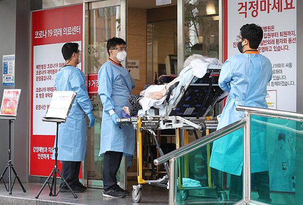 서울 광진구 혜민병원에서 구급대원들이 코로나19 환자를 옮기고 있다. (사진=저작권자(c) 연합뉴스, 무단 전재-재배포 금지)