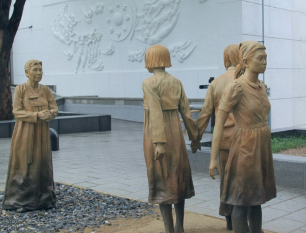 처음으로 일본군 위안부 피해 사실을 알린 김학순 할머니가 한국. 중국. 필리핀 소녀를 바라보는 모습을 한 서울 일본군 위안부 피해자 기림비