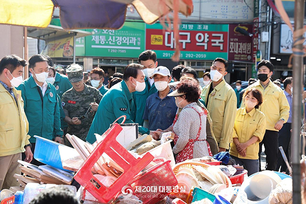 윤석열 대통령이 7일 오후 제11호 태풍 힌남노로 피해를 입은 경북 포항시 남구 오천시장을 방문, 피해 물품을 만지며 상인들과 대화하고 있다. (사진=대통령실)