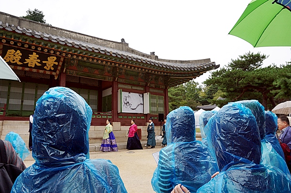 갑작스런 비로 우비를 입고 관람하는 관객들.