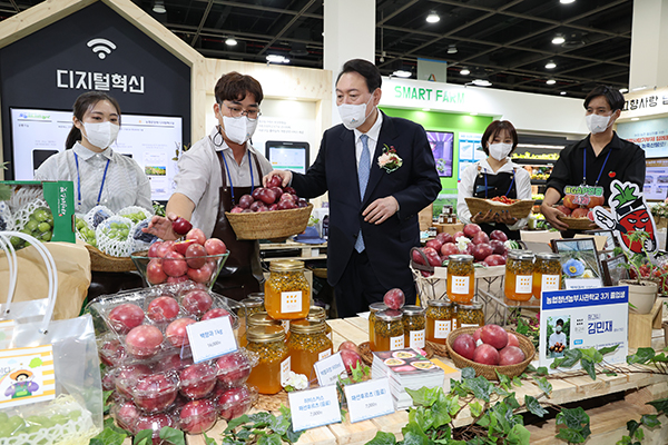 윤석열 대통령이 24일 서울 서초구 aT센터에서 열린 2022 창농·귀농 고향사랑 박람회를 방문, 청년농부가 생산한 백향과를 살펴보고 있다.(사진=저작권자(c) 연합뉴스, 무단 전재-재배포 금지)