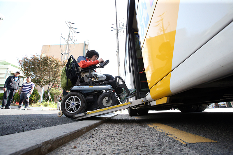 광주 북구의 한 버스정류장에서 전동휠체어를 탄 장애인이 저상버스에 오르고 있다.(사진=저작권자(c) 연합뉴스, 무단 전재-재배포 금지)