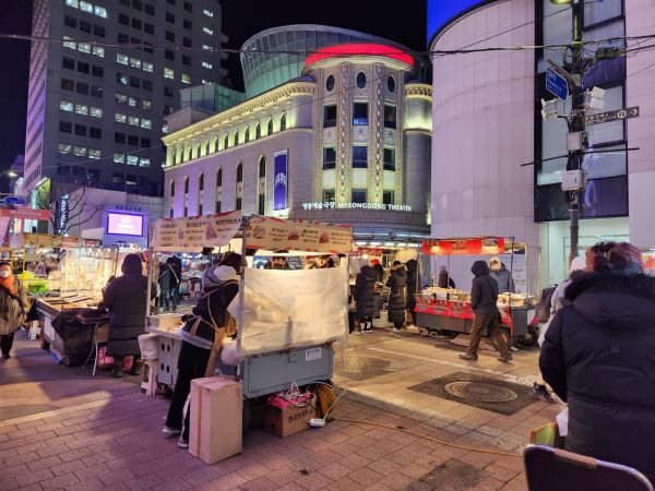 명동거리는 어두운 저녁에도 환하게 불을 밝히고 있다.