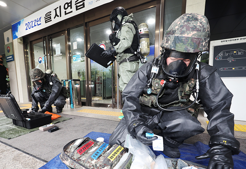 2022년 8월 23일 오후 세종시 정부세종청사에서 열린 2022 을지연습, 폭탄·화학 테러대비 모의훈련에서 출동한 32사단 화생방 지원대가 청사 앞에 뿌려진 백색가루 제독 작전을 실시하고 있다. (사진=저작권자(c) 연합뉴스, 무단 전재-재배포 금지)