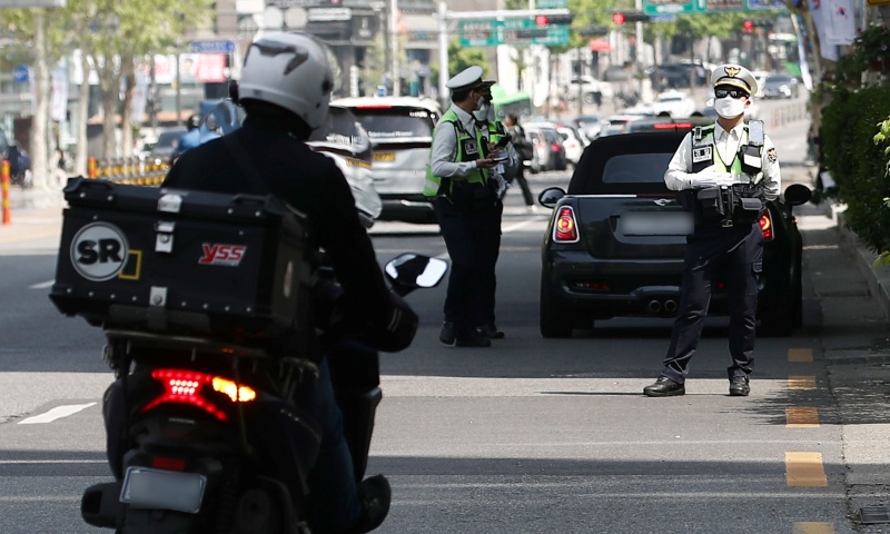 27일 서울 송파구 방이삼거리에서 경찰들이 우회전 시 일시정지 의무 위반 차량 단속을 하고 있다. 우회전 시 전방 차량 신호가 빨간불일 땐 보행자 유무와 무관하게 정지선이나 횡단보도 앞에서 일시 정지한 후 우회전해야 하며, 이를 어기면 도로교통법에 따라 승합차 7만 원, 승용차 6만 원, 이륜차 4만 원의 범칙금과 벌점 15점이 부과된다.(사진=저작권자(c) 뉴스1, 무단 전재-재배포 금지)