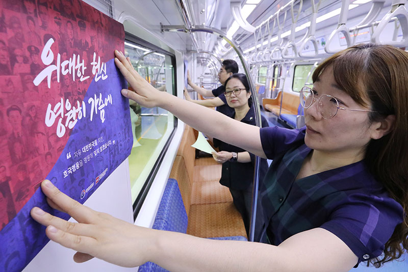 지난달 31일 경기도 수원시 영통구 신분당선 광교차량기지에서 열린 호국보훈열차 개통식에서 관계자가 홍보물을 부착하고 있다. 독립운동과 호국을 주제로 한 다양한 콘텐츠 홍보물로 구성된 호국보훈열차는 오는 6월 30일까지 약 한 달간 운행된다. (사진=저작권자(c) 연합뉴스, 무단 전재-재배포 금지)