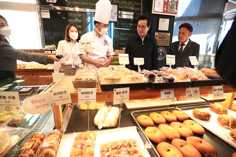정황근 농식품부 장관이 지난해 10월 13일 전북 익산에 위치한 가루쌀빵 베이커리를 방문해 진열된 제품들을 살펴보고 있다.(사진=농식품부)