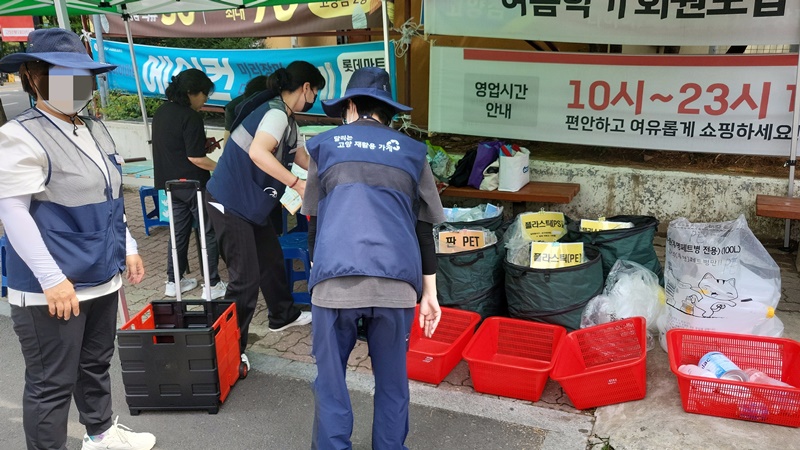 자원순환 가게에 방문한 사람들이 분리수거를 하고 있다.