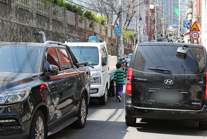 부산 동래구 한 초등학교에 불법 주차된 차량 옆으로 한 어린이가 아찔한 보행을 하고 있다. (사진=저작권자(c) 연합뉴스, 무단 전재-재배포 금지)