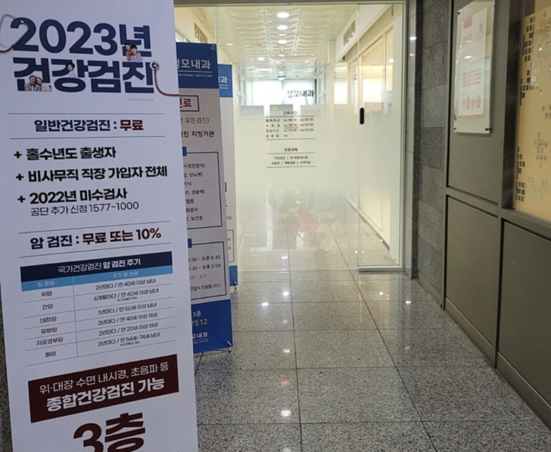 Informações sobre exames médicos em 2023 estão expostas em frente à entrada do hospital.