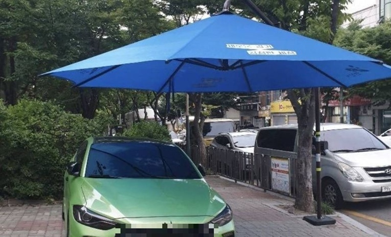 인도 그늘막 아래 주차한 차량.