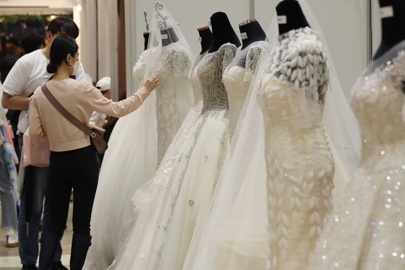 웨딩박람회에서 예비 신랑 신부들이 웨딩드레스를 둘러보고 있는 모습.(사진=저작권자(c) 연합뉴스, 무단 전재-재배포 금지)