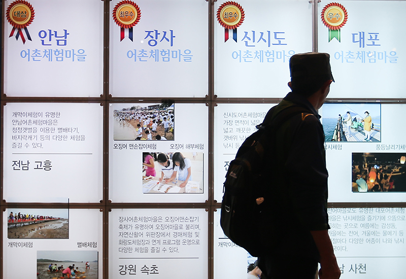 한 시민이 어촌체험마을 정보를 살펴보고 있다. (사진=저작권자(c) 연합뉴스, 무단 전재-재배포 금지)