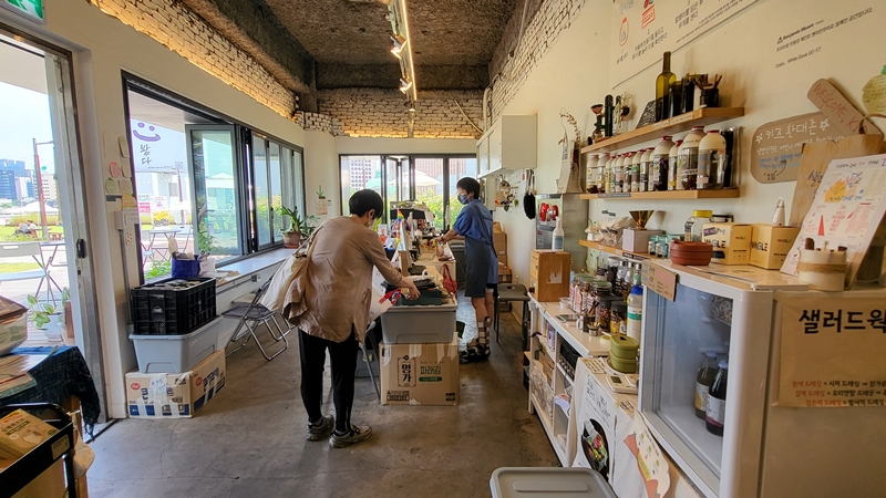 제로웨이스트 샵에서 용액을 구매하면서 무게를 직접 재고 있는 시민.