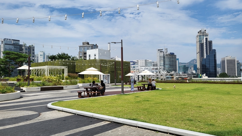 서울역 옥상정원 잔디밭에서 여유를 즐기는 사람들.