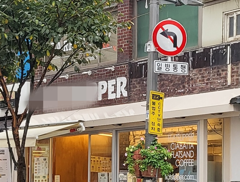 판매 중인 메뉴와 상관 없는 영어 간판을 달고 있는 카페.