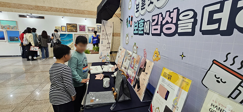 지난달 25일 평송청소년문화센터에서 열린 학교예술교육박람회에서 선보인 보훈디자인 용품을 초등학생들이 관람하고 있다. (사진=나라사랑신문)