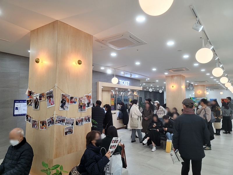 로비에서 다양한 세대의 관객들이 공연을 기다리고 있다.