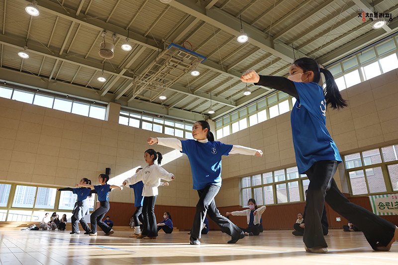 송린초등학교 늘봄학교 맞춤형 방과후학교 프로그램인 치어리딩부 ‘블루웨이브’ 공연반이 학내 강당에서 치어리딩 연기를 위해 동작을 맞추고 있다.