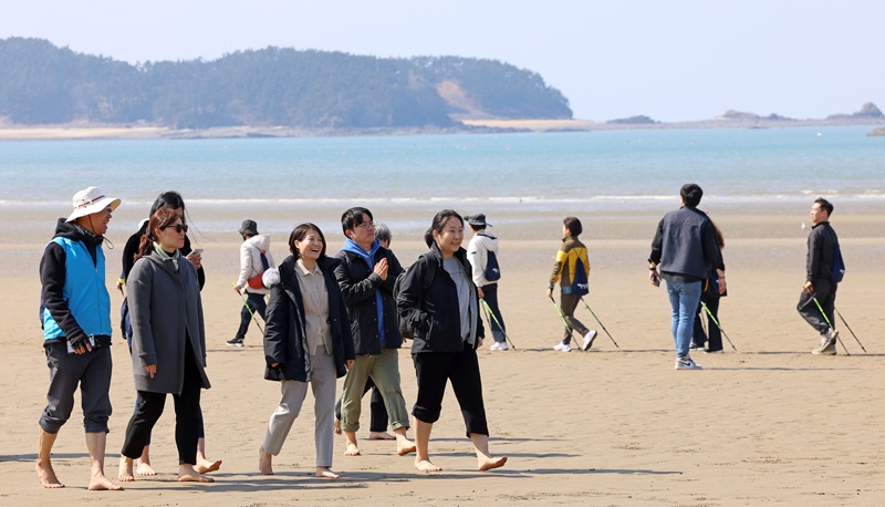 장미란 문화체육관광부 제2차관이 15일 ‘3월엔 여기로: 여행가는 달, 기차로 떠나는 로컬여행’ 프로그램을 이용해 충남 태안을 찾아 신두리 해수욕장에서 기자단과 함께 맨발 걷기(어씽)을 체험하고 있다. 맨발 걷기(어씽)는 지구(earth)의 땅을 직접 밟는다는 의미로 스트래스 감소와 운동성 증가 등의 효과가 있어 황톳길, 등산로, 해안가 등에서 최근 유행하고 있는 활동이다. (사진=문화체육관광부)