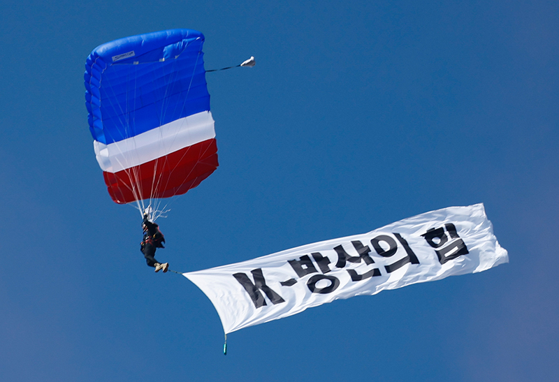 지난해 10월 16일 경기 성남시 서울공항에서 열린 서울 국제 항공우주·방위산업 전시회(ADEX) 2023 프레스 데이에서 열린 한미 공군 연합작전 시범에서 우리 공군이 낙하산을 매고 ‘K-방산의 힘’ 현수막을 펼친 채 하강하고 있다. (ⓒ뉴스1, 무단 전재-재배포 금지)