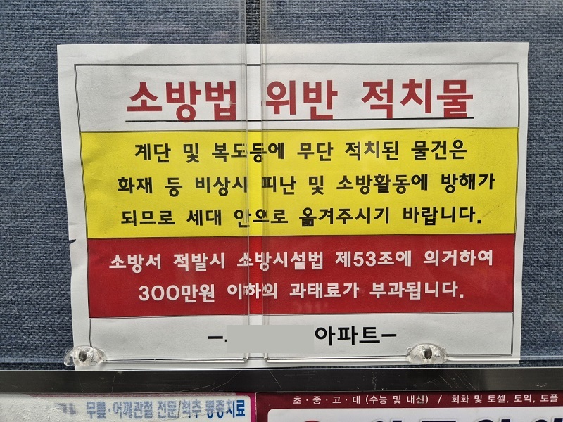 아파트 안내판에 게재된 소방법 위반 적치물 제거 공지.