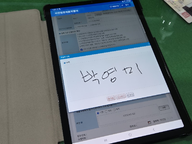 사전연명의료의향서에 대해 정확하게 이해하고 태블릿PC에 사인.