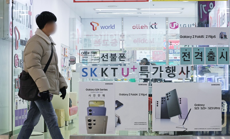 서울의 한 휴대폰 매장 앞으로 시민이 지나가고 있다. 2024.2.22.(ⓒ뉴스1, 무단 전재-재배포 금지)