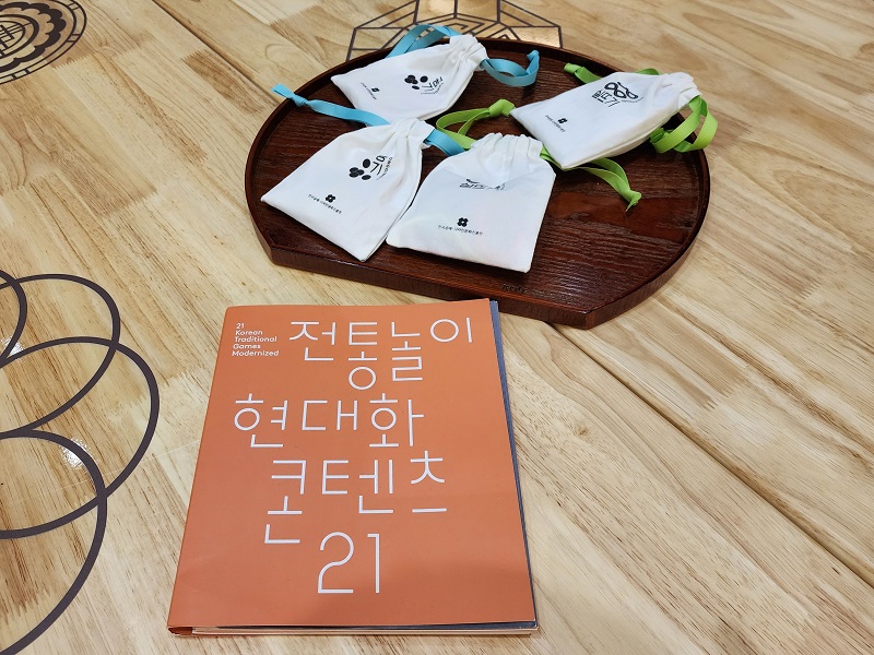 공진원이 발간한 '전통놀이 현대화 콘텐츠 21' 책자와 전통놀이 콘텐츠.