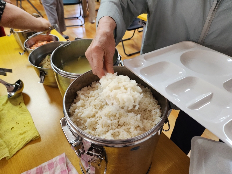 낮 12시 전후 럭키아파트 경로당에 모인 어르신이 급식판에 각자 먹을 분량의 음식을 덜고 있다.