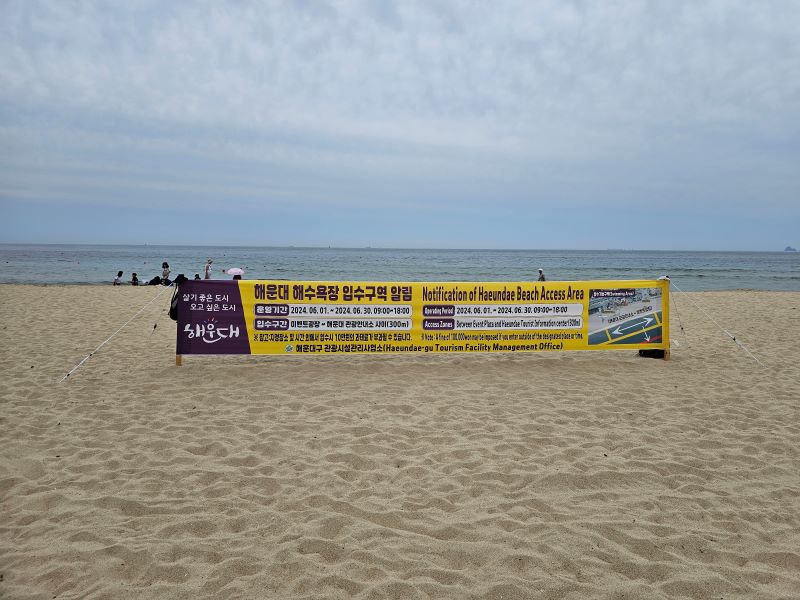 해운대 해수욕장 입구 근처에 세워져있던 안내플랜카드. 해수욕장 개방 기간과 이용시간, 개방구역 등이 표기되어있었다.