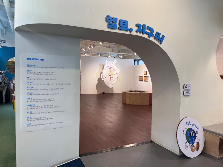 '헬로, 지구씨' 전시 입구. 업사이클링 재료로 꾸며진 아치형 입구와 내부 공간이 보인다.