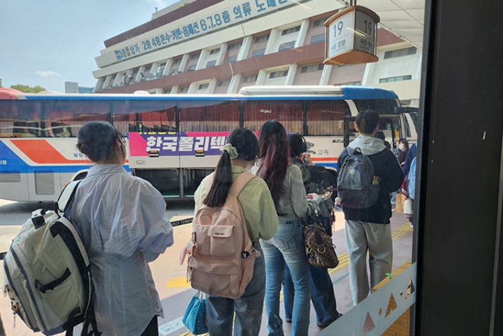 고속버스를 탑승하려는 승객들이 줄 지어 있다.