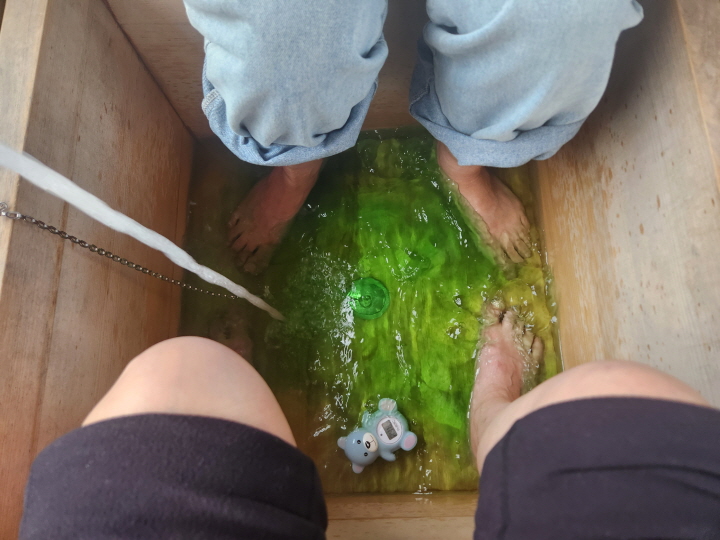 누각에 앉아서 약초를 푼 따듯한 물에 두 발을 담그는 약초 족욕을 체험했다.