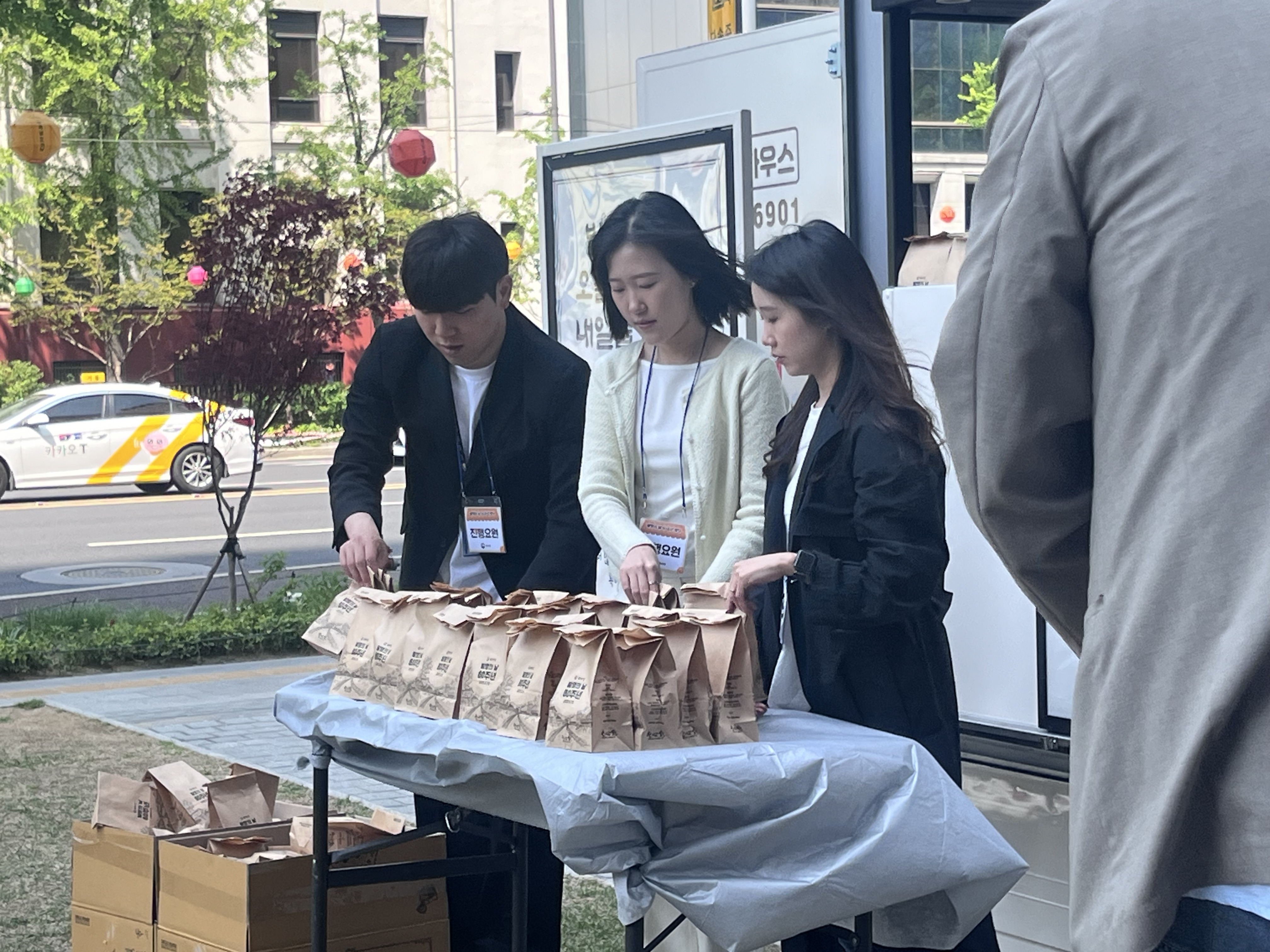 특허청 직원들이 테이블 위에 준비된 다수의 빵봉투를 정리하고 있는 모습.