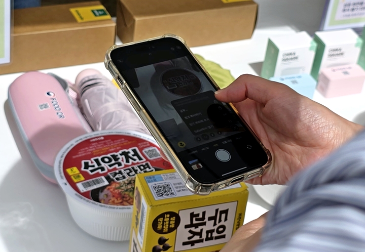 한 시민이 푸드 QR을 스캔해보고 있다.