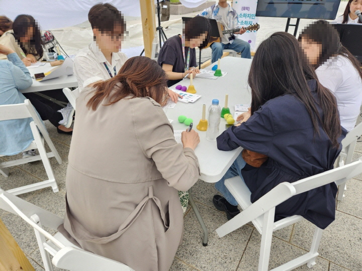 참여자가 사진엽서 뒷면에 각자의 소소하지만 소소하지 않은 일상을 적고 있다.