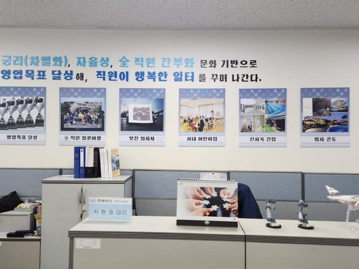 주식회사 토마스 사무실 벽면에 걸린 '직원이 행복한 일터'라는 글이 눈에 띈다.