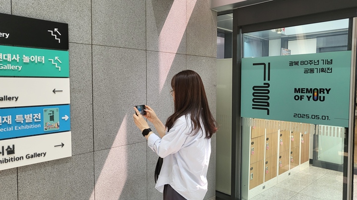 전시 정보를 살펴보고 있는 관람객, <기록> 특별전은 7월 6일까지 대한민국 역사박물관에서 열린다.