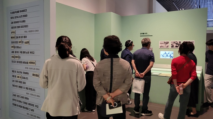 관람객들이 기록물에 대한 설명을 듣고 있다.