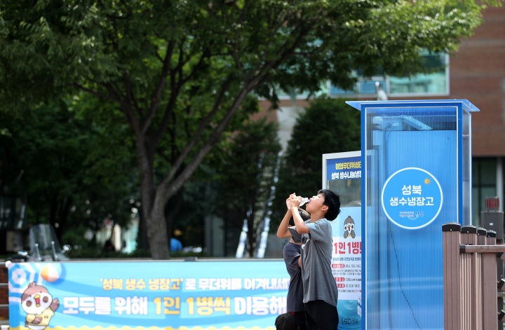 서울 성북구 바람마당에 설치된 '생수 나눔 냉장고'에서 학생들이 생수를 꺼내 목을 축이고 있다. 2024.7.14. (ⓒ뉴스1, 무단 전재-재배포 금지)
