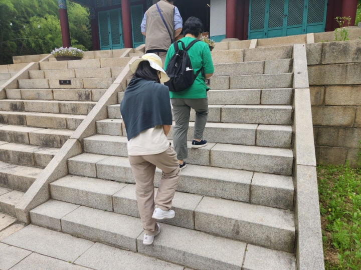 참여자들이 충장사로 가는 계단을 오르면서 두 발을 가지런히 모으고 있다.