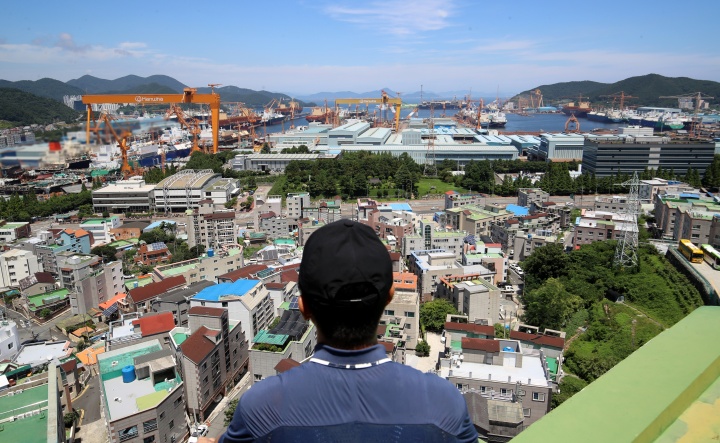 한 시민이 경남 거제시 아주동 주거단지 너머로 조선소 대형 크레인을 바라보고 있다.(ⓒ뉴스1, 무단 전재-재배포 금지)