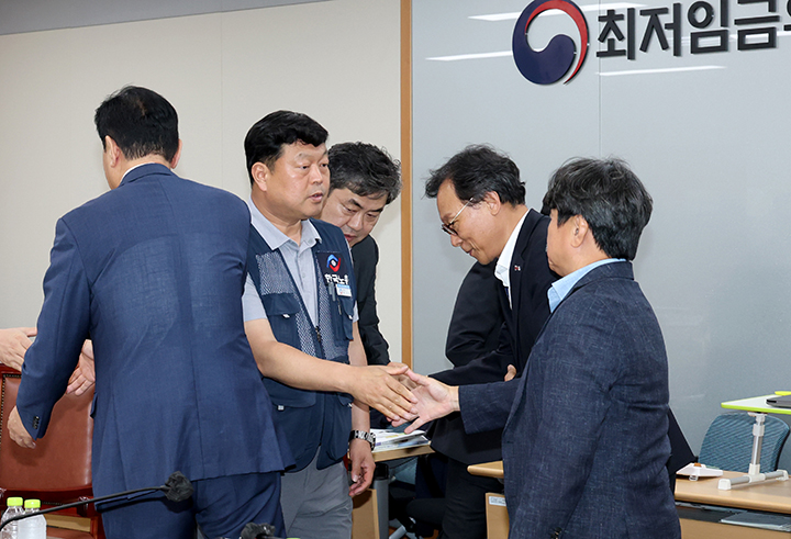 최저임금위원회 제12차 전원회의에서 사용자위원과 한국노총 근로자위원들만이 참여해 2026년 최저임금을 1만 320원으로 합의하며 류기정 사용자위원과 류기섭 근로자위원 등이 회의장을 떠나며 인사를 나누고 있다. 2025.7.10 (ⓒ뉴스1, 무단 전재-재배포 금지)