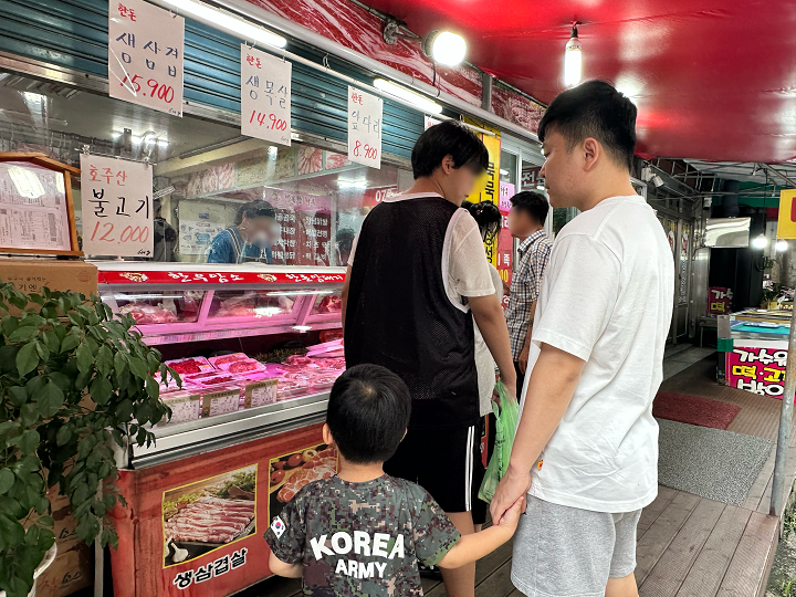 정육점에서 민생회복 소비쿠폰으로 고기를 사고 있는 아이와 남편.
