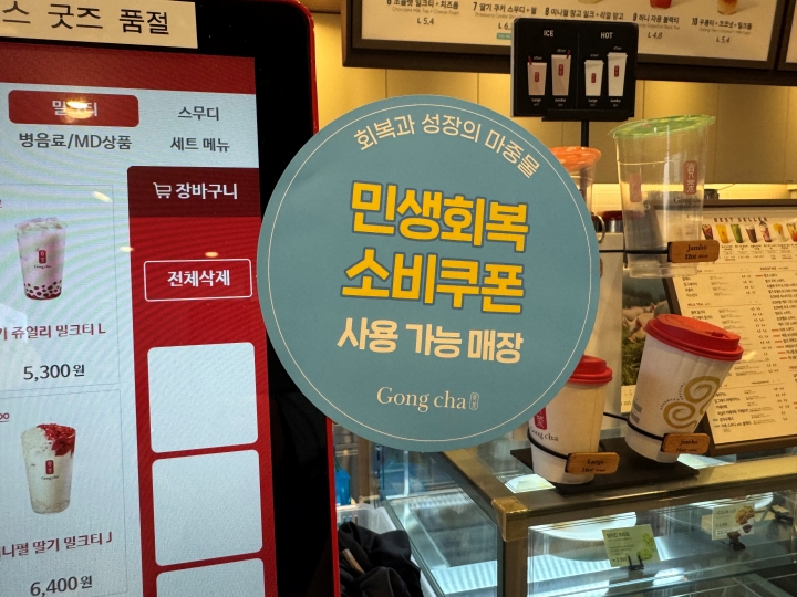 동네 카페에 붙어있는 '민생회복 소비쿠폰' 사용 가능 매장 안내 문구.